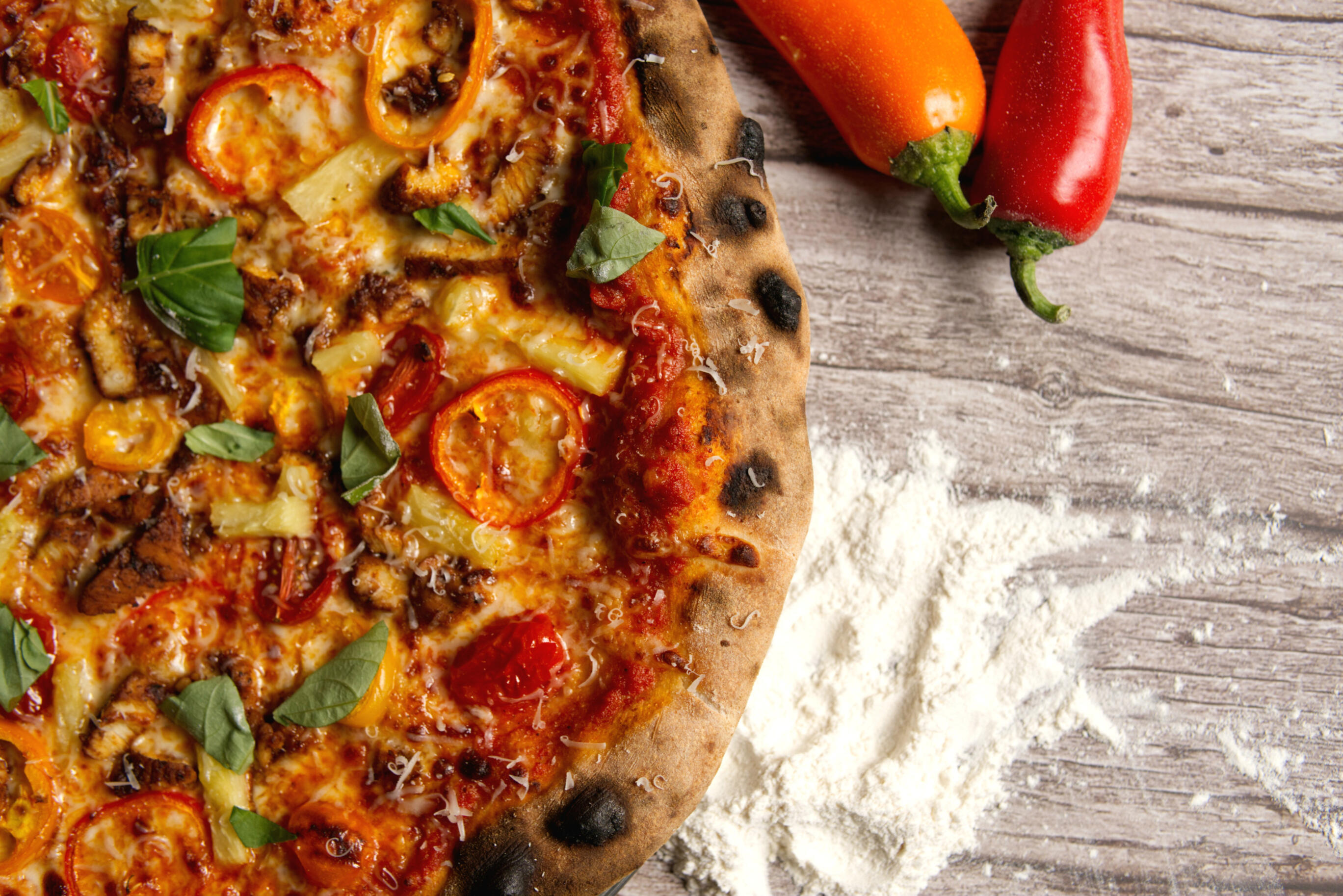 Menu picture of a person topping a pizza