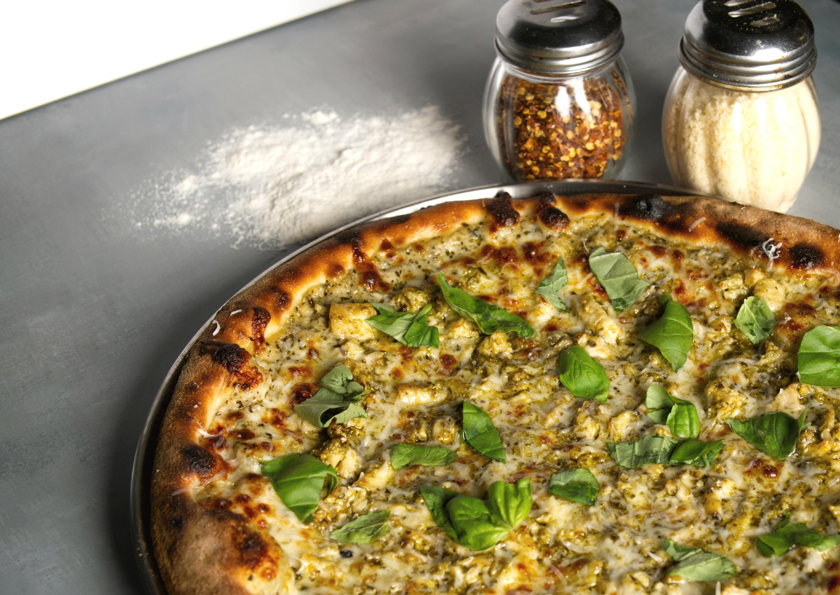 Menu picture of a person topping a pizza